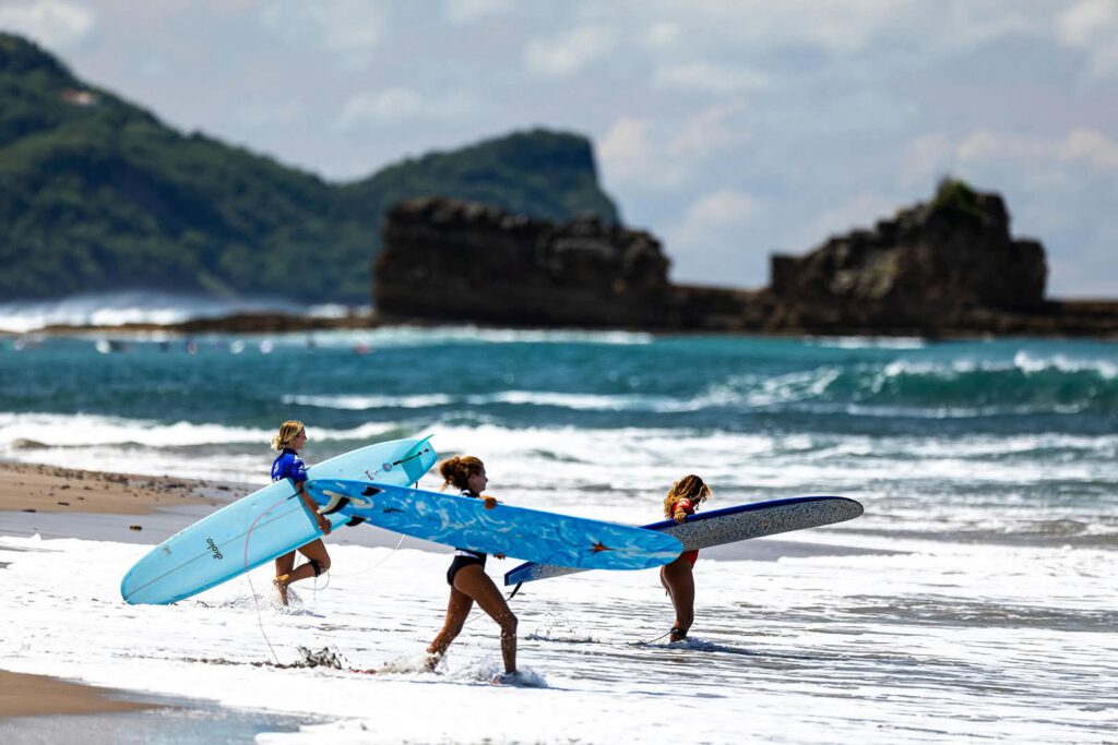 Three girls wading through the surf and getting ready to shred the gnar!